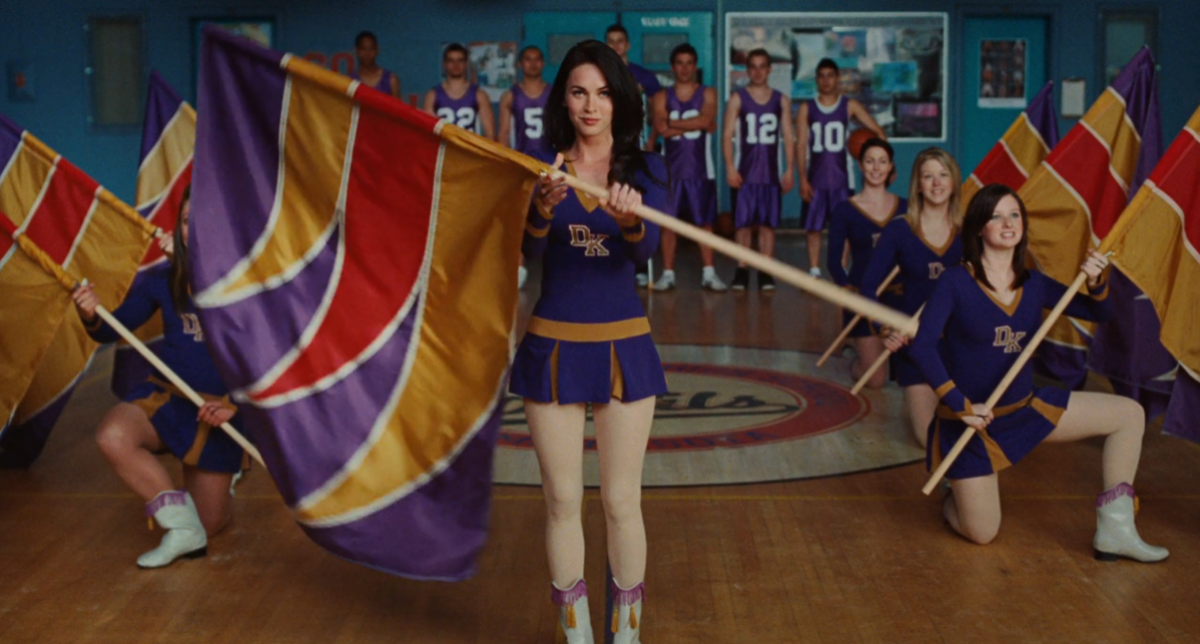 Jennifer in Jennifer's Body wears a cheer uniform and twirls a flag.