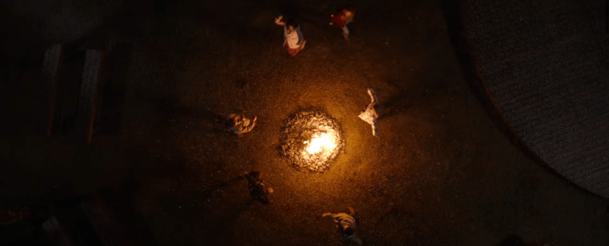 A group of people dancing around a fire