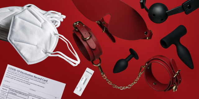 Against a red background, there is a stack of white KN95 masks, a COVID vaccine card, a rapid covid test, red leather cuffs, a red leather blindfold, two black butt plugs, and a black ball gag.