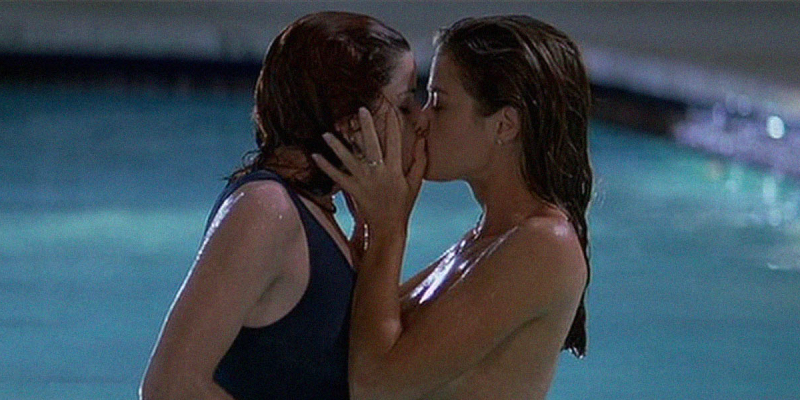 Denise Richards and Neve Campbell kiss in a pool.