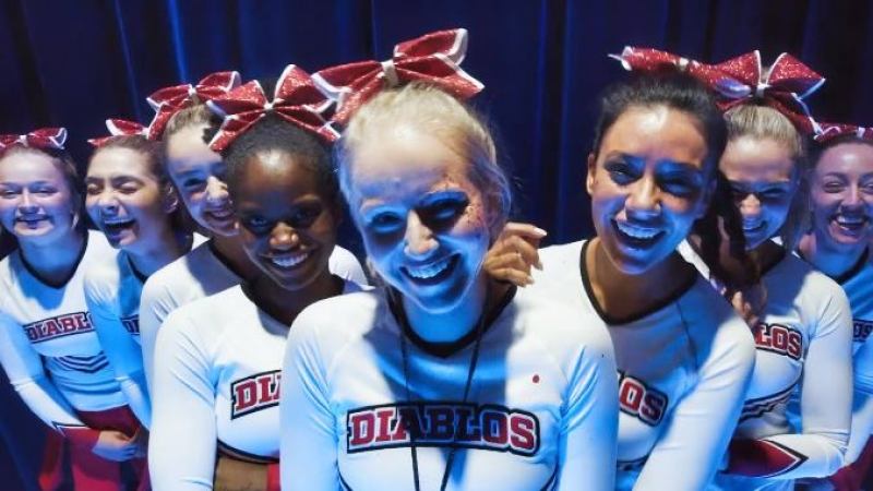 A group of Cheerleaders stands in their uniforms which say DIABLOS.