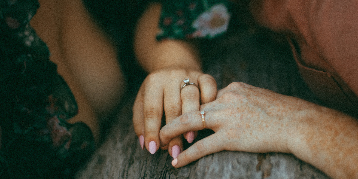 Vanessa's wedding engagement, featuring a close-up of two hands with rings on a piece of wood