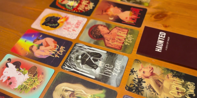 The Haunted tarot deck features illustrations with a haunted forrest vibe, featuring skeletons, animals, and horror-esque characters.