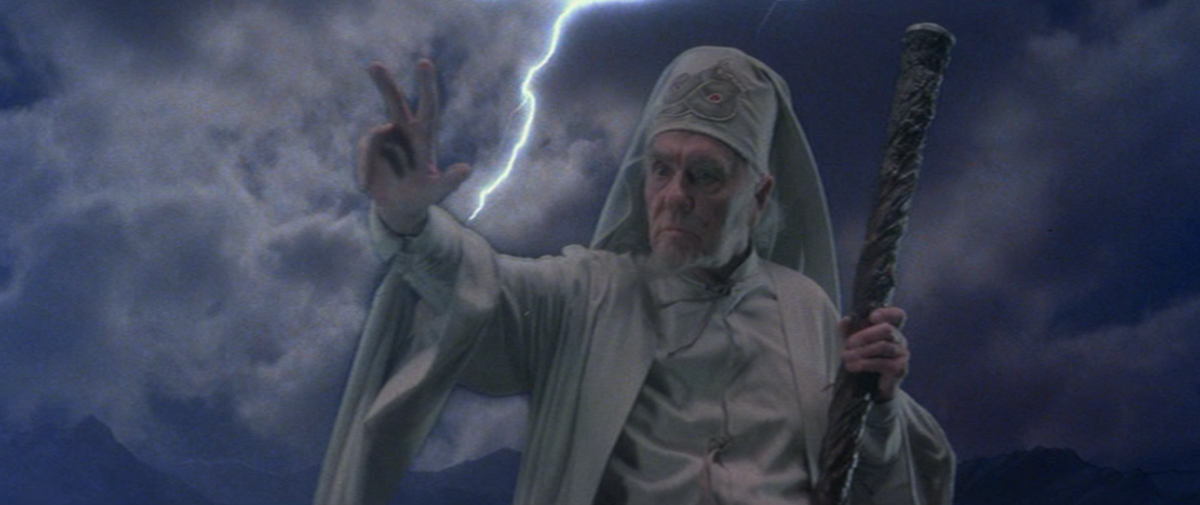 an old white guy wizard in a white outfit gestures while lightning strikes behind him