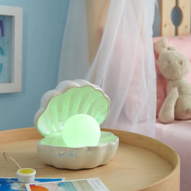 A clam light on a table next to a bed