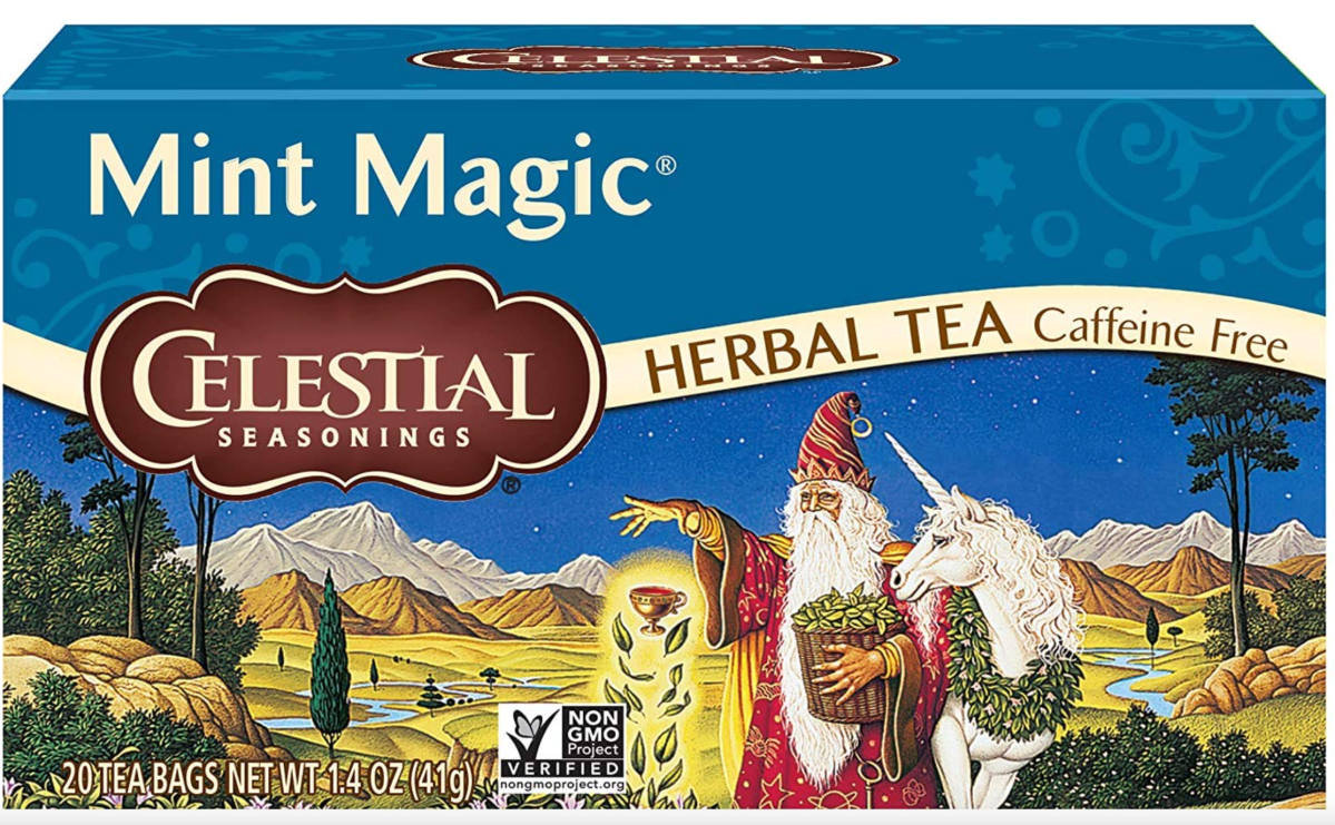 a photo of the celestial seasonings mint magic box. it has a wizard in a red robe with giant white beard levitating a goblet on it. a unicorn cozies up next to him. there is a lush landscape in the background.