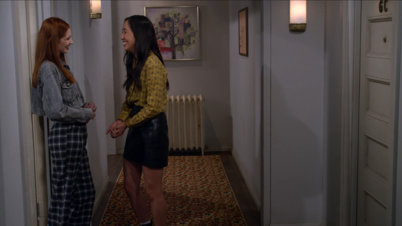 Ellen and Rachel giggle nervously together in the hallway