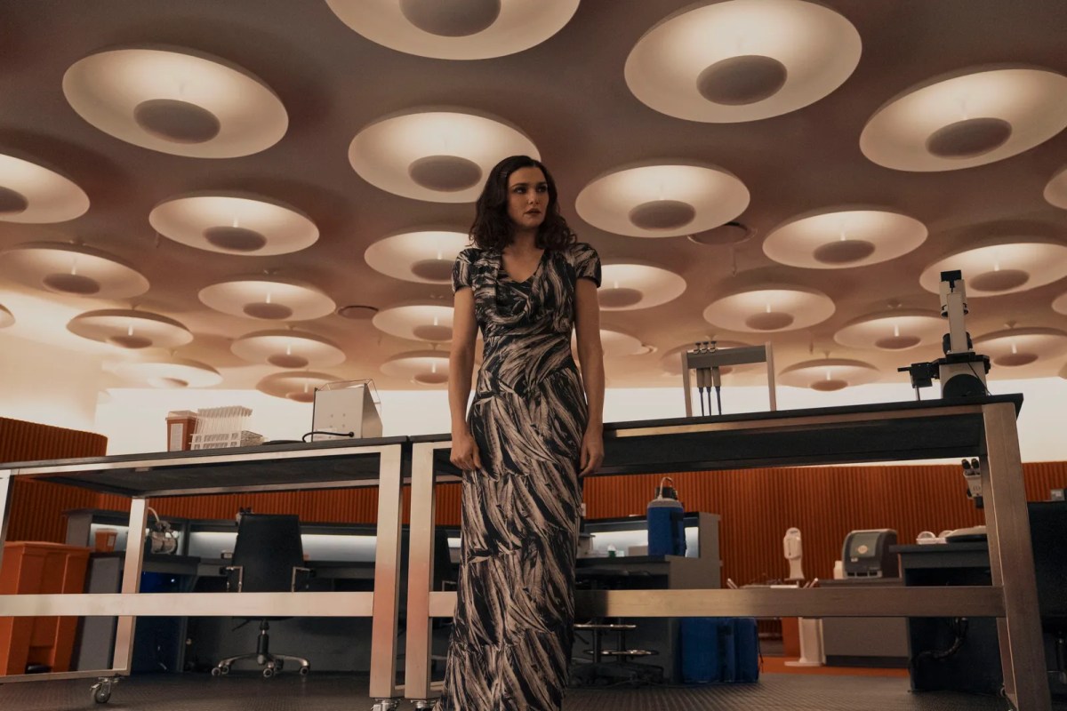 Rachel Weisz wears a long white and black swirly dress in a medical lab