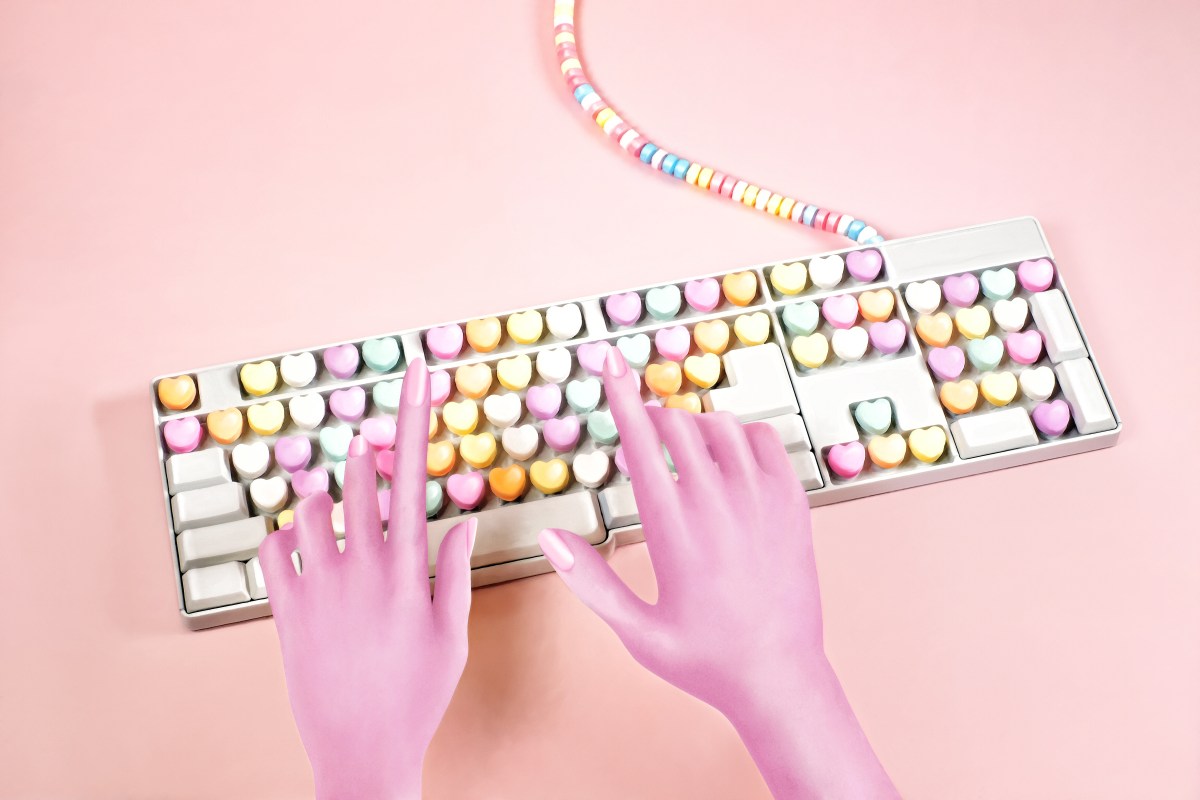 Digital illustration of woman's hands tying on a computer keyboard with candy heart keys.