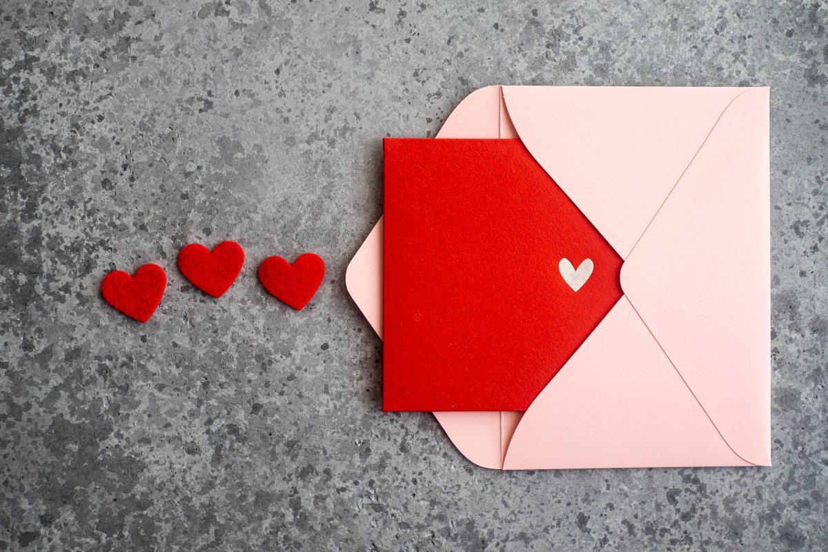 A printed red Valentine in a pink envelope with small hearts emanating from it