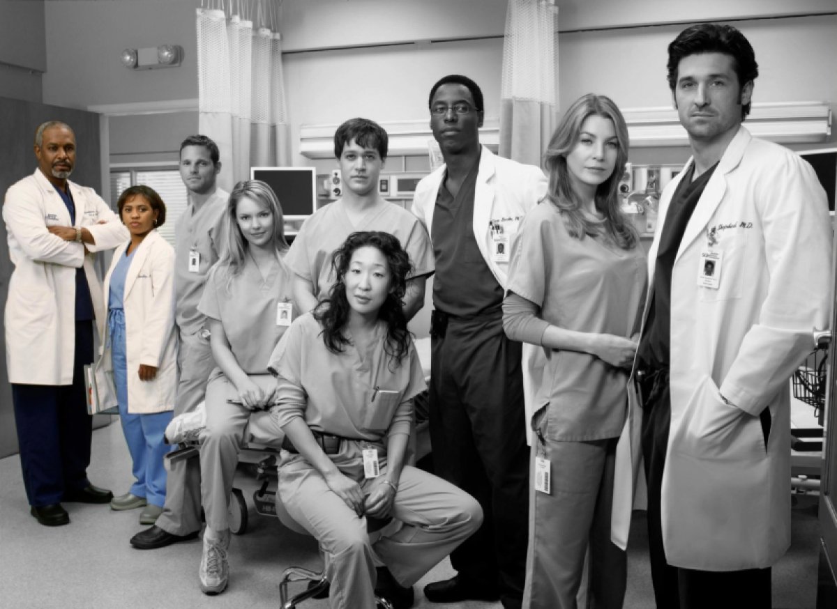 A black and white photo of the original cast of Grey's Anatomy, with only Dr. Webber and Dr. Bailey remaining in color