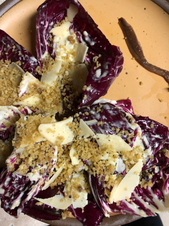 a radicchio salad with shaved parmesan, anchovy breadcrumbs, and one full anchovy on the side 