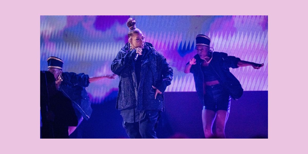 Queen Latifah on stage in a sparkly black jacket at the Grammys