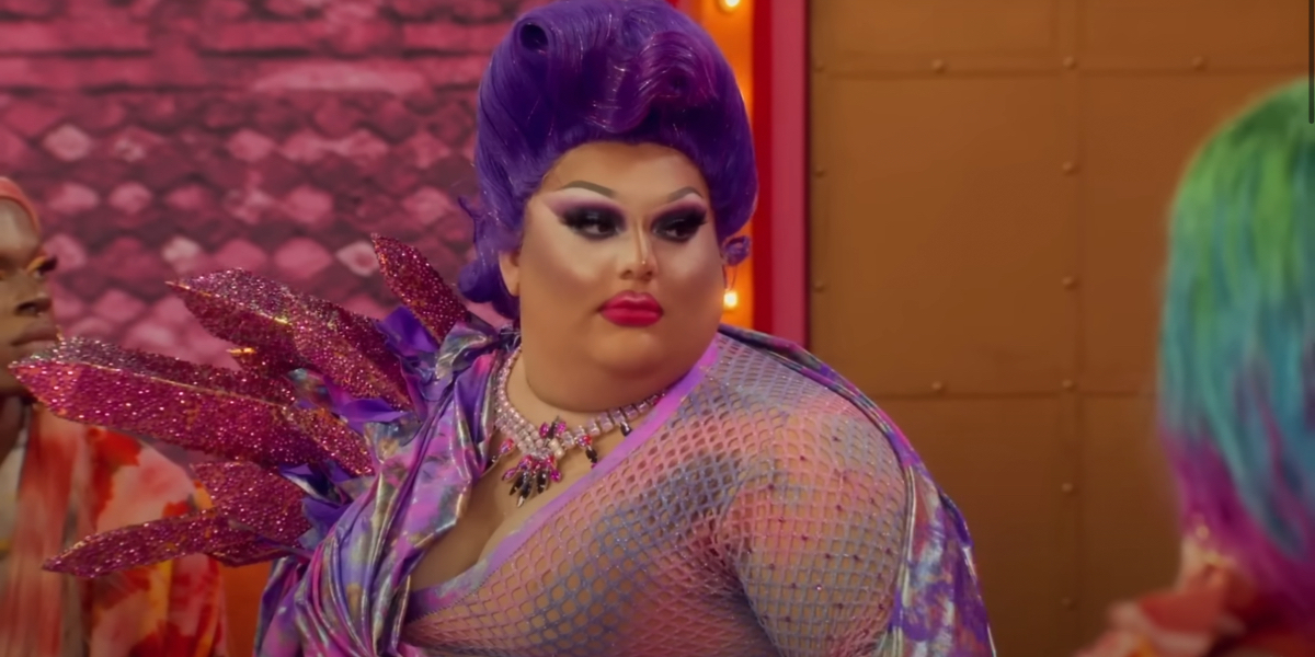 Drag Race 1507 recap: Mistress in a multicolored fishnet top and purple hair gives a shady look off to the side.