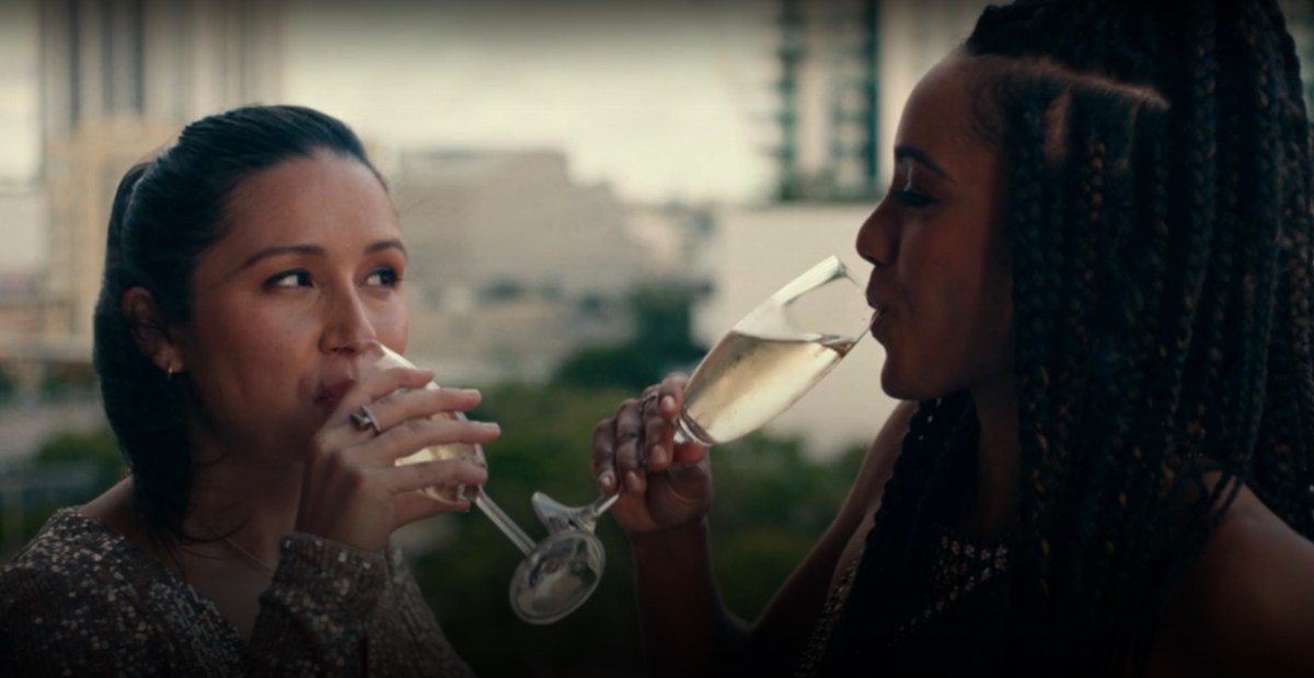 Two women drinking wine facing each other