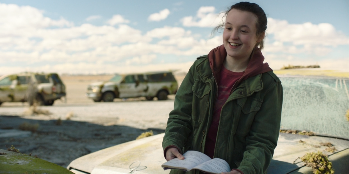 The Last of Us: Bella Ramsey as Ellie, smiling as she reads from her pun book