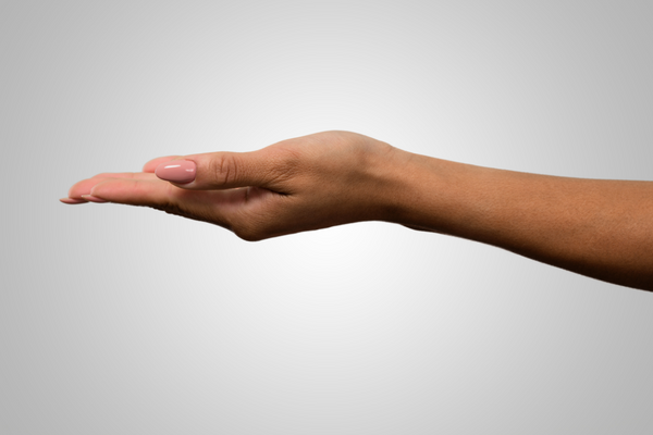 A Black woman's hand extends from the right side of the image against a gray background. Her palm faces up.