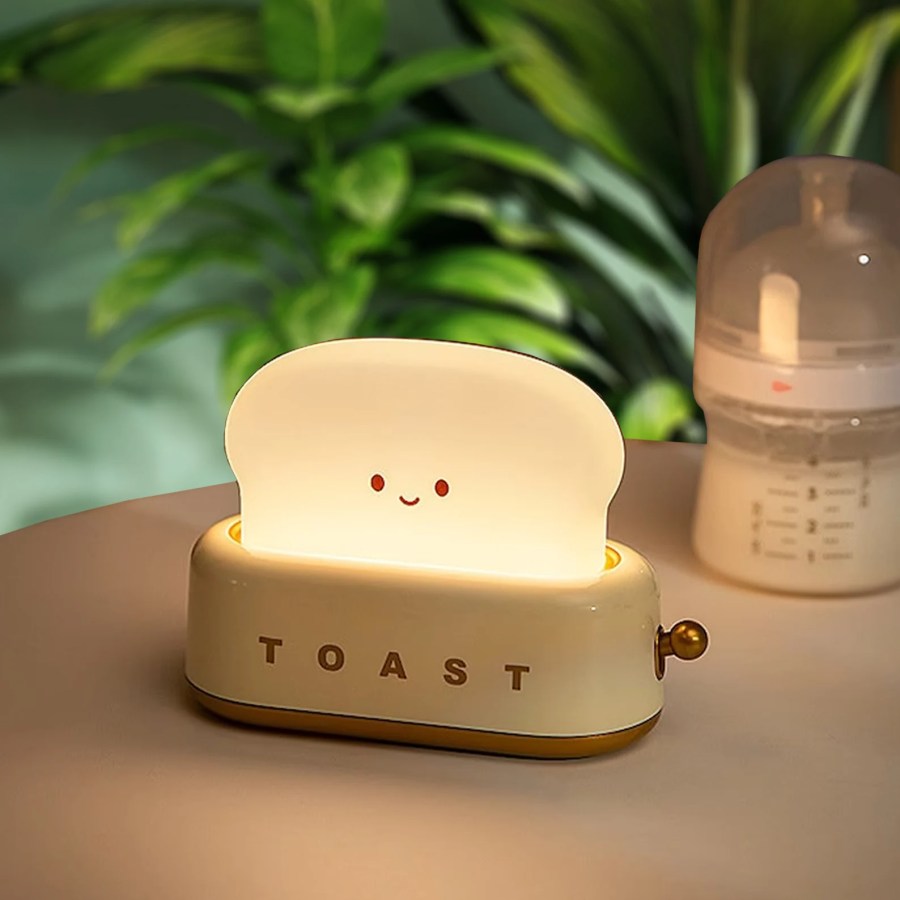 a small lamp shaped like a toaster with smiling toast coming out of it