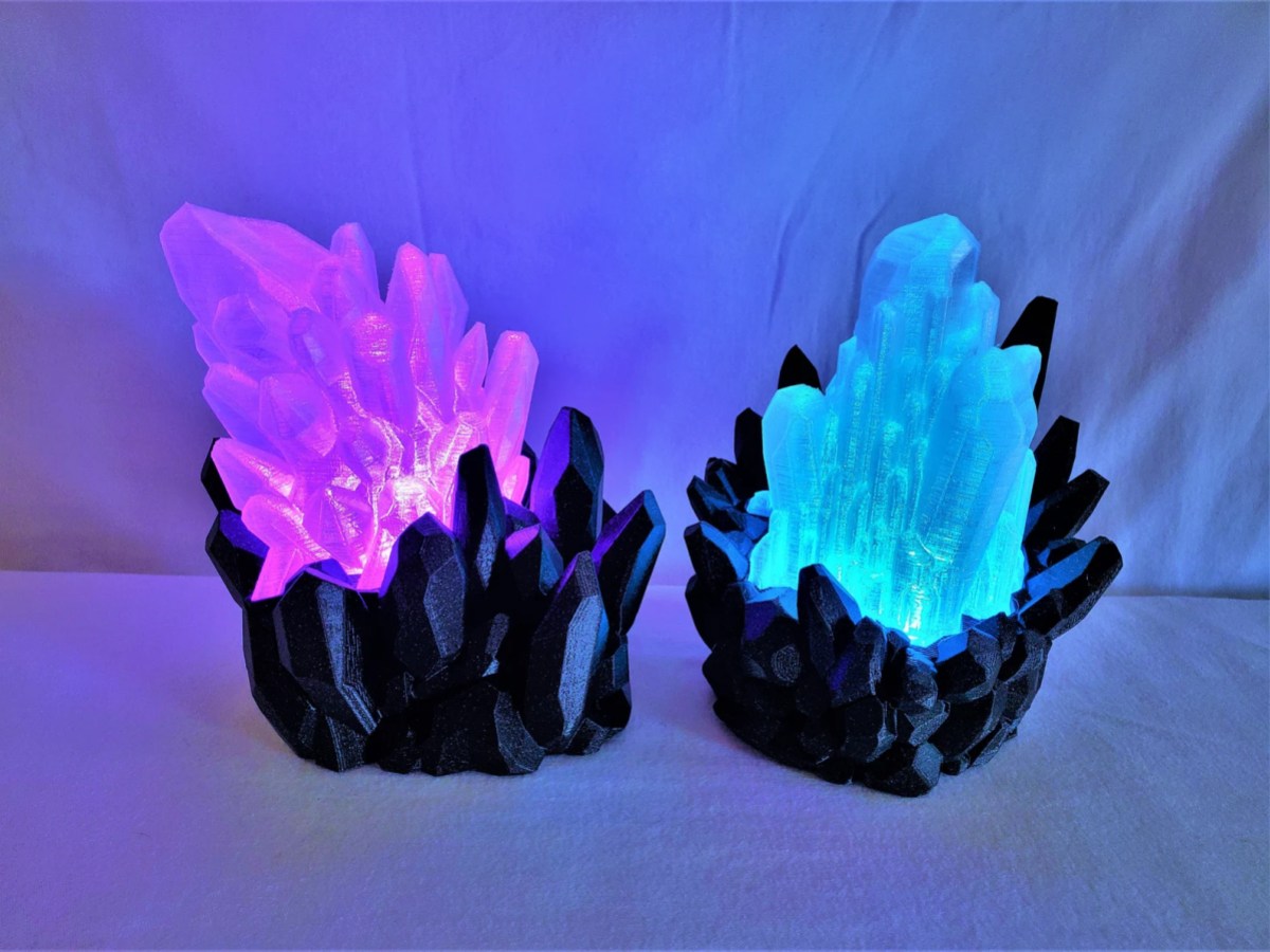 two lamps shaped like crystal clusters. one is pink and one is blue