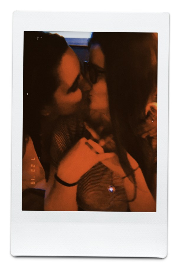 Kayla and Kristen kissing in a low lit bar