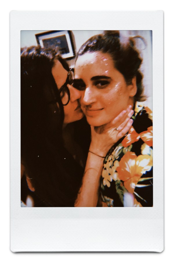 Kristen has her hand on Kayla's throat and is kissing her cheek
