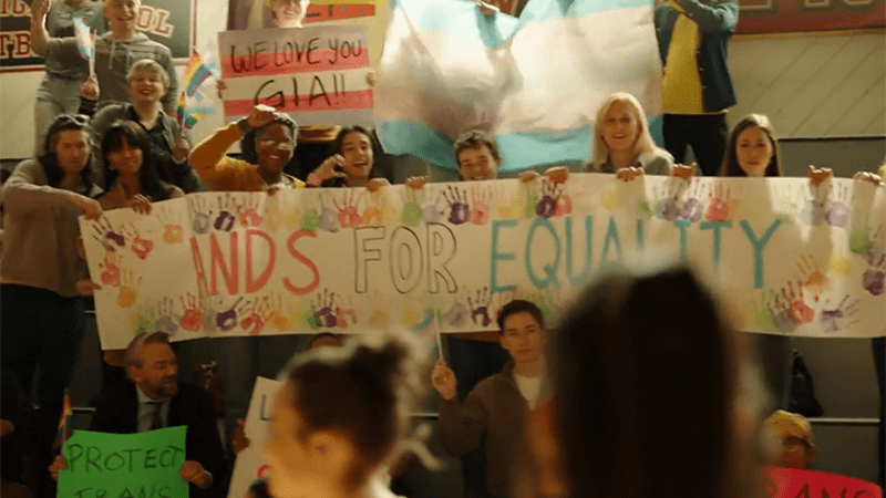 On Quantum Leap, a group of fans hold a sign that says "hands for equality" 