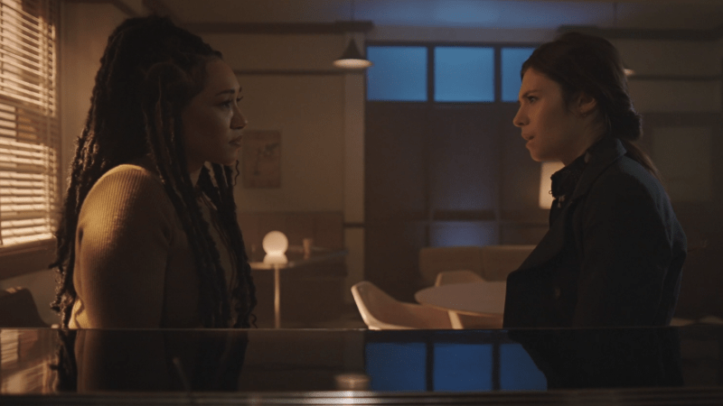 Iris and Nia talk in a dream office