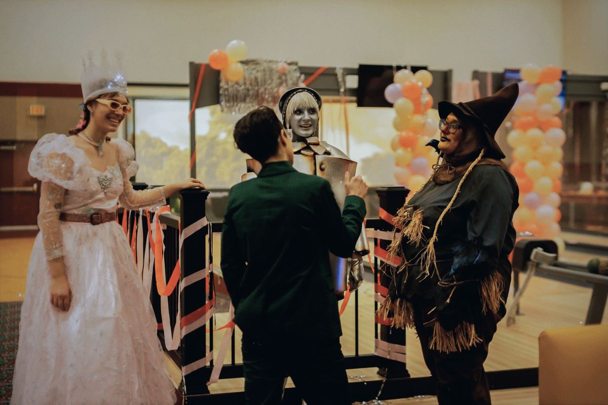 a group of people dressed as Wizard Of Oz characters for the "Night Shift" video, including Carmen Maria Machado as a scarecrow