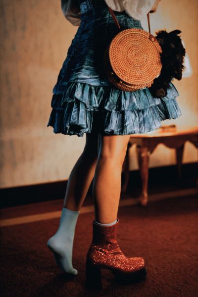 a woman in a Dorothy costume with one sparkly red shoe missing