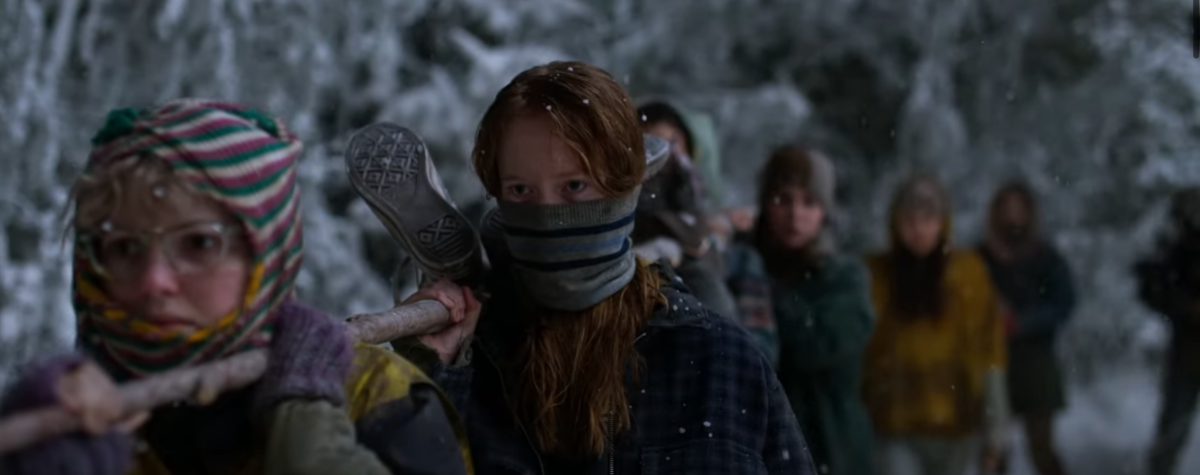 Misty and Van and some other girls carry a large stick in the snowy woods and sneakers pop up, suggesting a human body is tied to the stick in the Yellowjackets season 2 trailer.