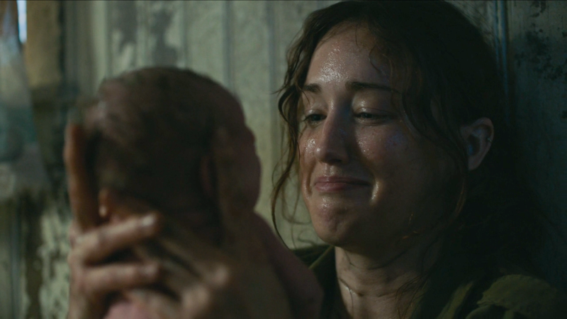 The Last of Us: Ashley Johnson as Anna holds baby Ellie and smiles at her through tears