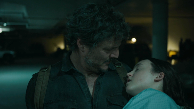 The Last of Us: Pedro Pascal as Joel looks down as Bella Ramsey as Ellie in his arms