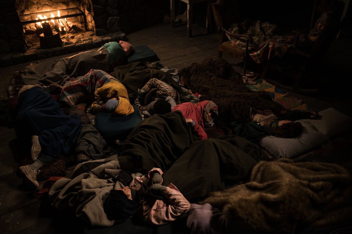 A still from YELLOWJACKETS showing everyone in the cabin asleep. Season 2. Photo Credit: Kailey Schwerman/SHOWTIME.