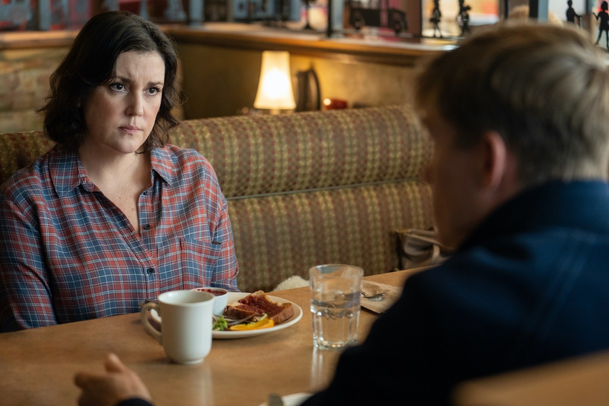 Melanie Lynskey as Shauna in YELLOWJACKETS Season 2 is in a diner booth across from Jeff. Photo Credit: Colin Bentley/SHOWTIME.