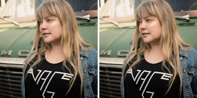 Zoe Whittall has blunt blonde bangs with straight hair past her shoulders and wears a black tee that says VAG on it as well as a jean jacket. There's a green truck behind her.