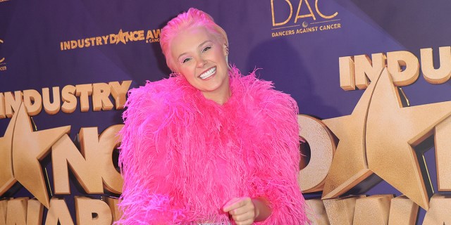 JoJo Siwa un a pink fur wrap and pink hair in the red carpet