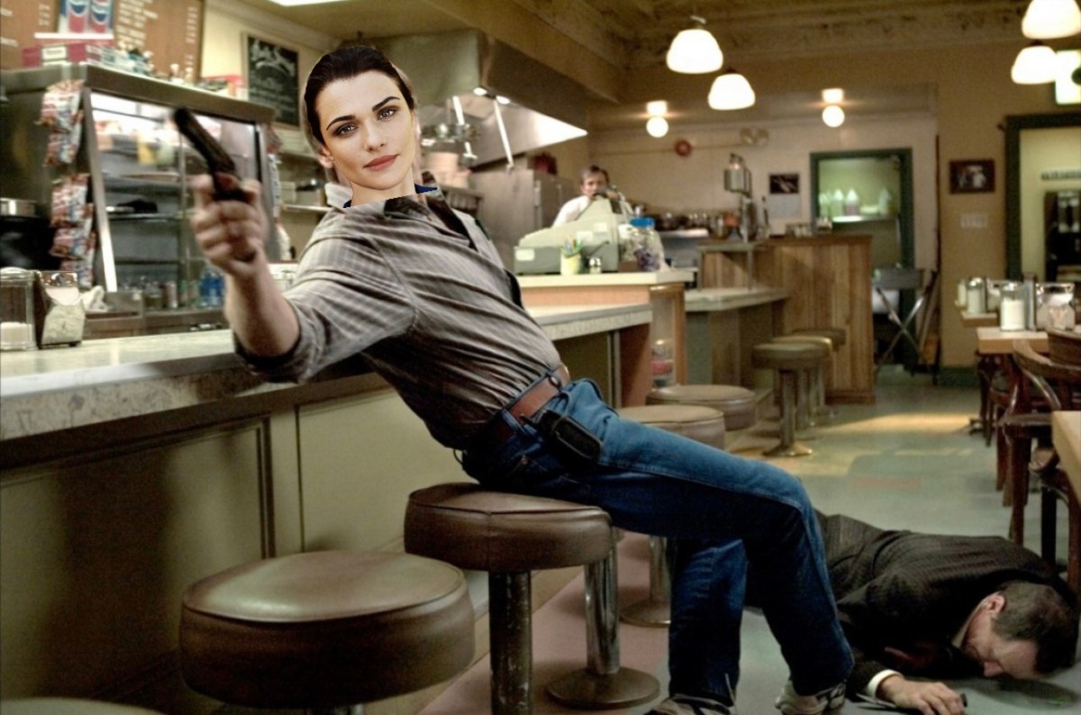 A still from A History of Violence of Viggo Mortensen sitting on a diner stool pointing a gun with Rachel Weisz's head poorly photoshopped on his body.
