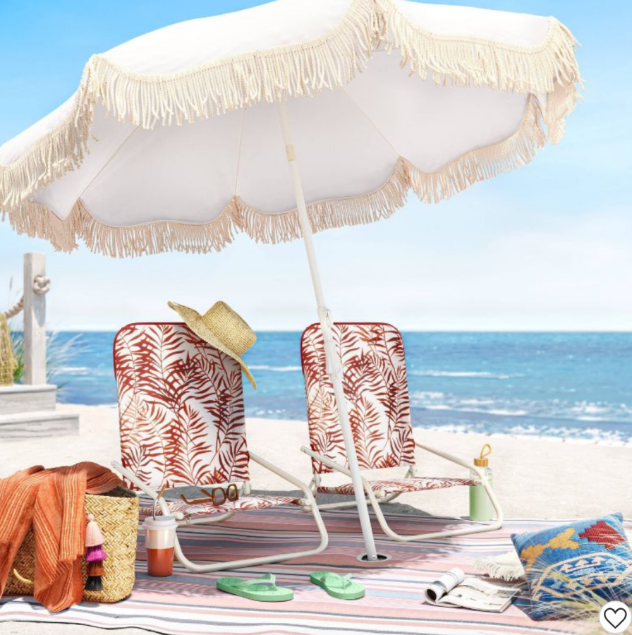 a fringed beige umbrella on the beach