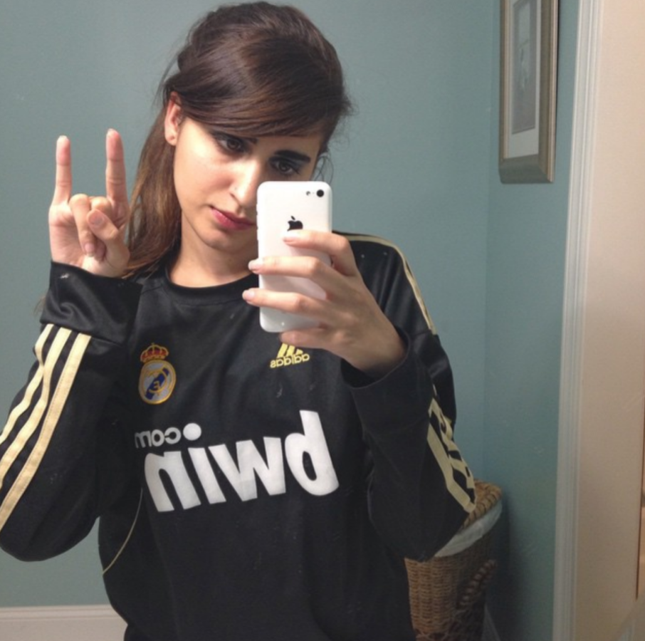 Kayla Kumari Upadhyaya with straightened hair and side bangs wearing a Real Madrid soccer jersey and taking a mirror selfie