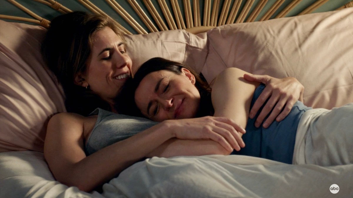 Kai and Amelia are in bed together in Grey's Anatomy, they are holding each other.