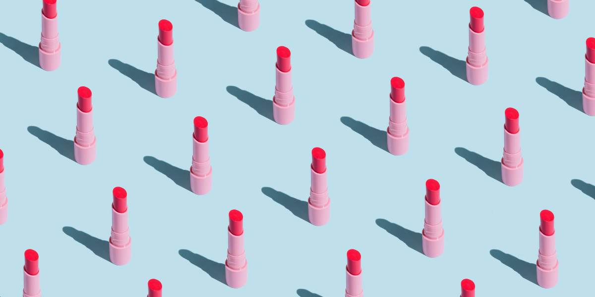 a bunch of lipstick lined up on a blue background