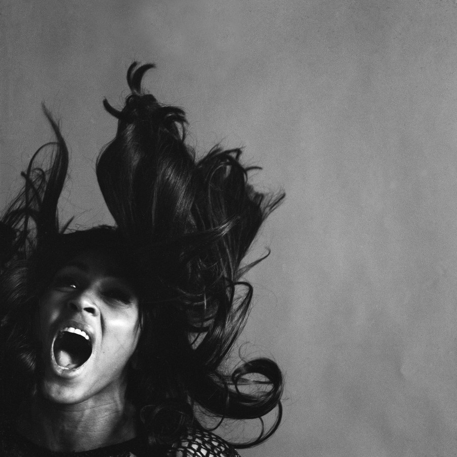 A black and white photo of a young Tina Turner screaming.