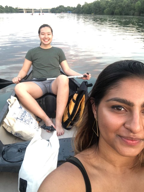 MR and Ashni looking up at the camera. MR is holding a canoe paddle and is wearing a green t-shirt. Ashni is wearing a slip dress.
