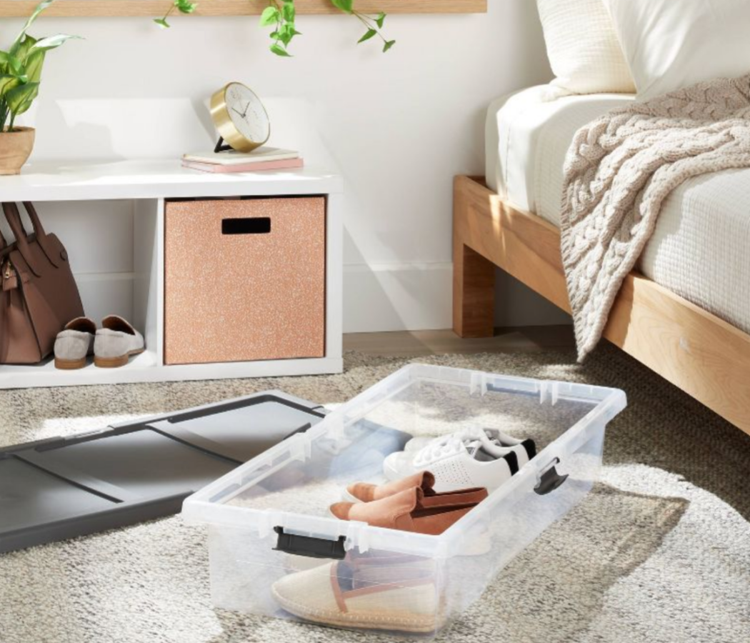 a clear storage box that fits under a bed filled with shoes