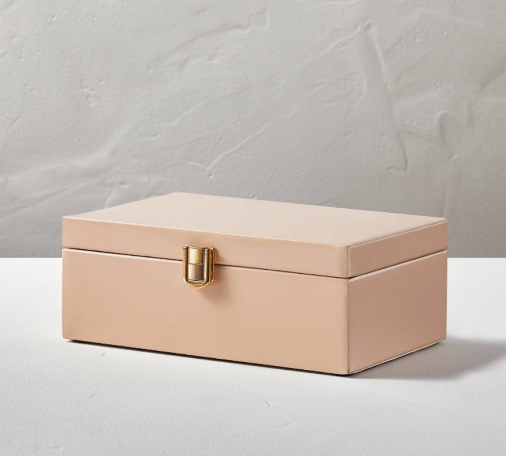 a pink metal box with a gold latch
