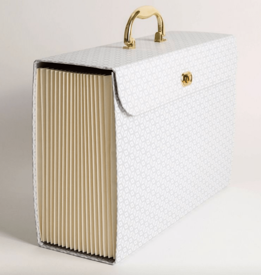 a white expandable file folder with a gold handle