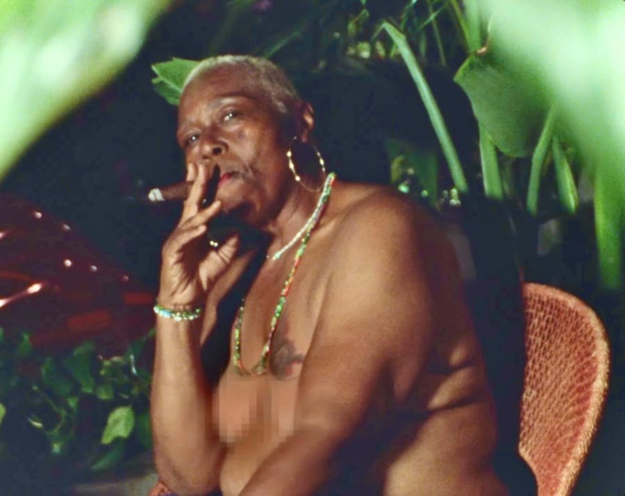 A black queer elder smoking a cigar