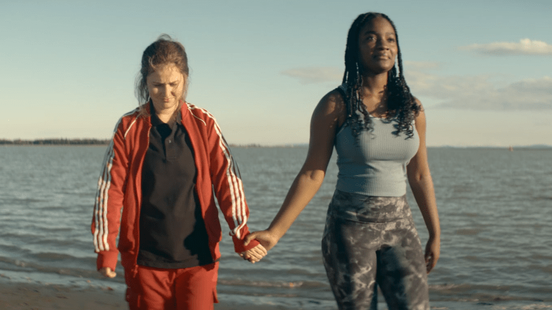 The Power: Roxy and Eve hold hands on the beach