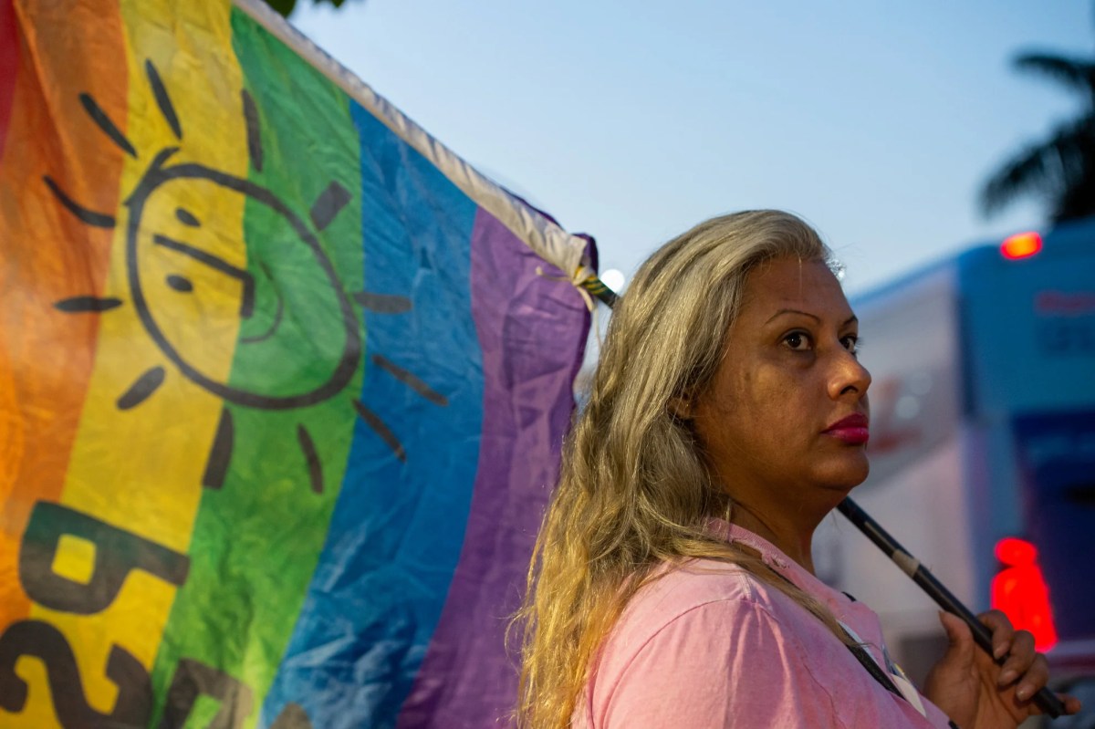 Indianara Siqueira holding a Pride flag in the documentary Your Mother's Comfort