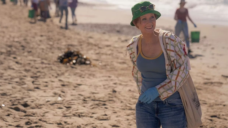 Miranda in a green bucket hat on the beach. 